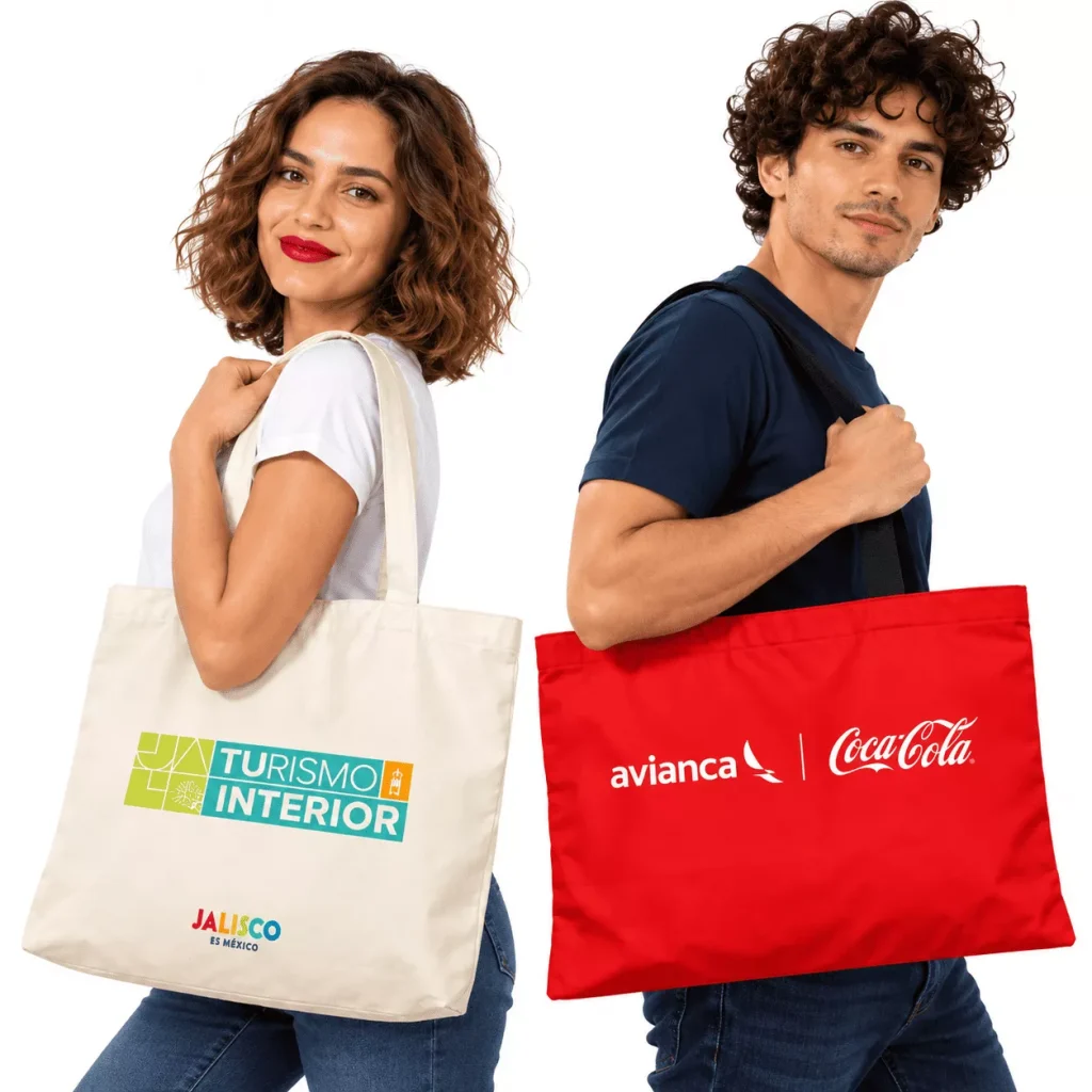 Modelos luciendo bolsas tote ecológicas de lona personalizadas con los logotipos de Turismo Interior de Jalisco, Avianca y Coca-Cola para campañas en Colombia.