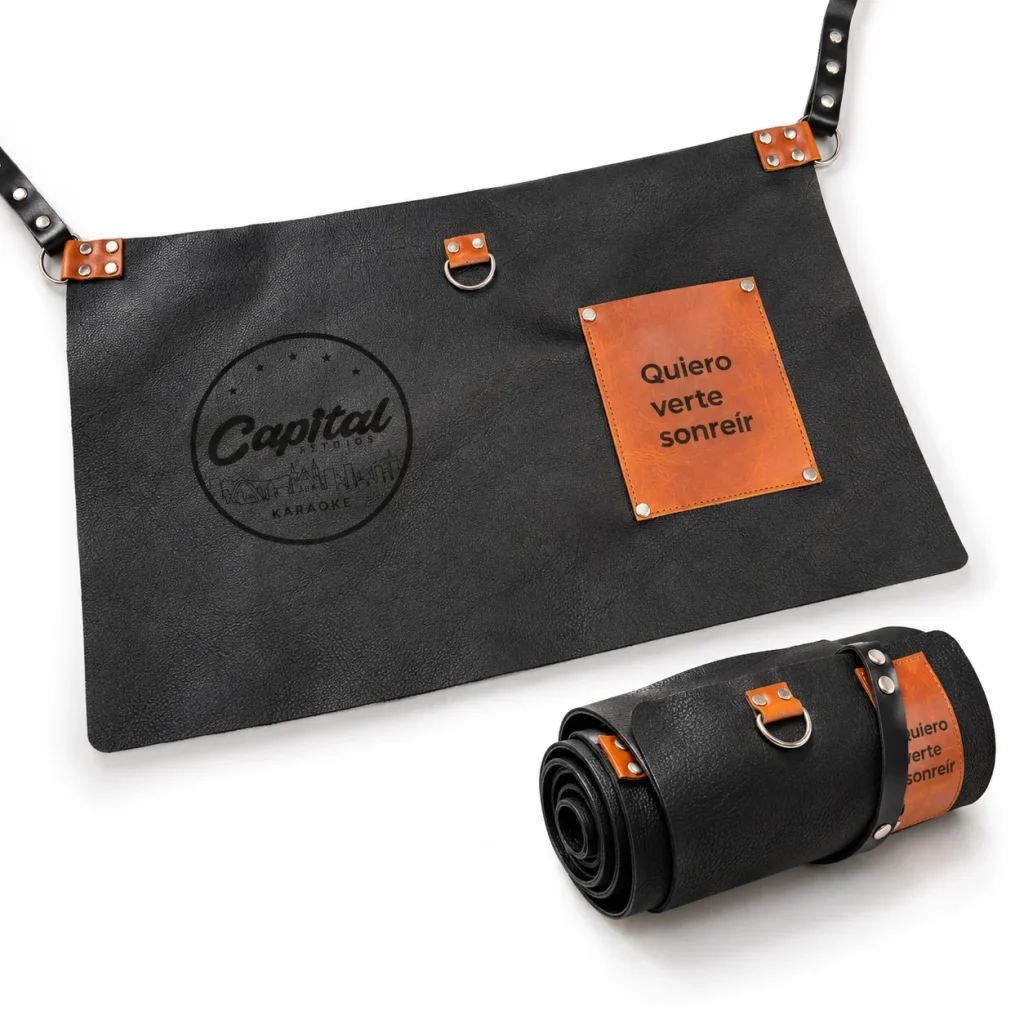 Delantal de cuero negro artesanal con correa enrollable y grabado personalizado de Capital Studios para dotaciones corporativas en Bogota